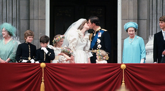 Prince Charles and Lady Diana Spencer kiss on their wedding day surrounded by members of the royal family on the balcony of Buckingham Palace.