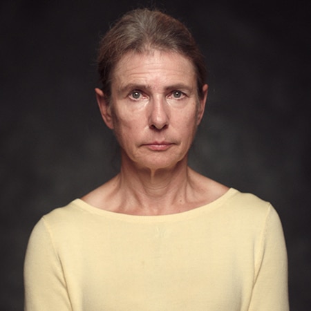 Lionel Shriver looking into camera in front of a dark background