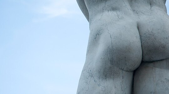 A marble statue of a male’s buttocks