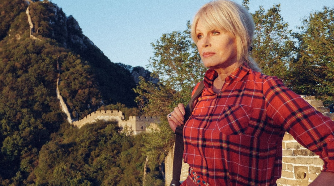 Joanna Lumley looks into the distance wearing a red checked shirt