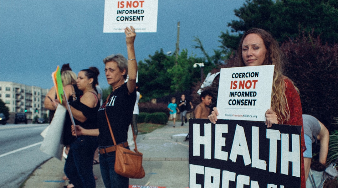 Anti-vaxx protesters holding up signs