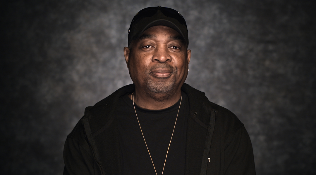 Chuck D wears a black hoody and black cap